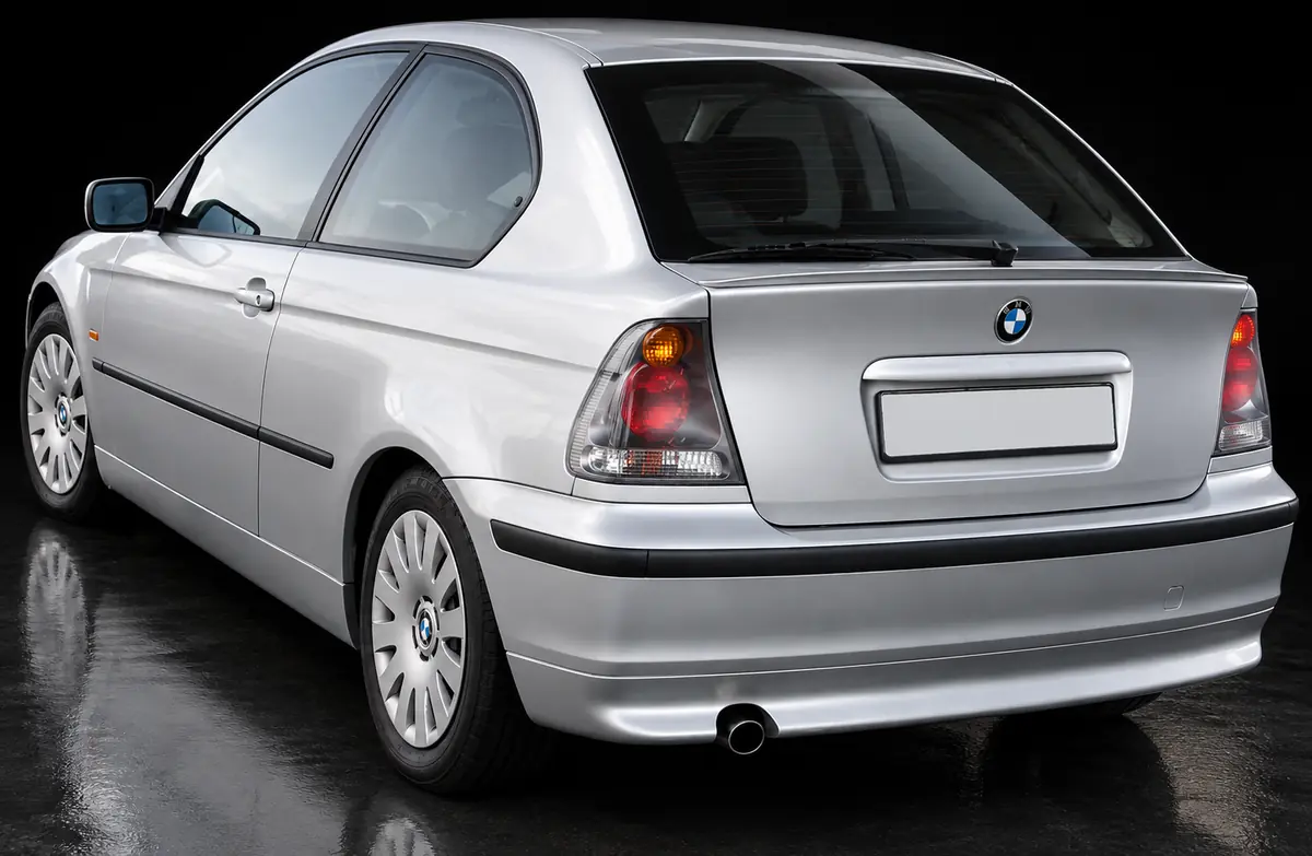AI illustration of a silver E46 Compact, rear three-quarter view, with the standard rear bumper and a single exhaust